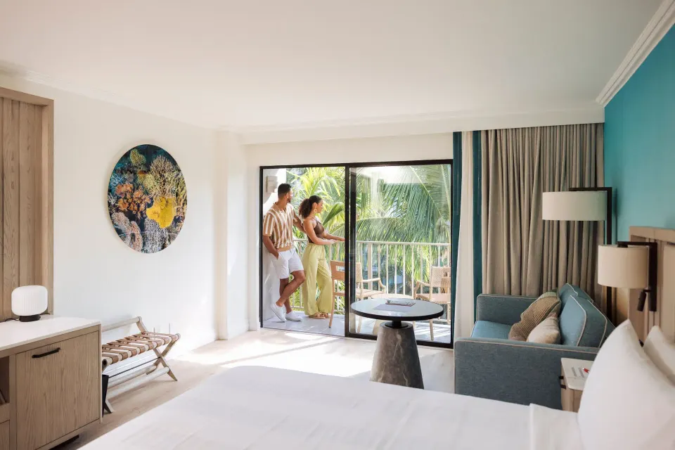 Guest room with sofa bed, balcony doors and partial bed view at Grand Cayman Marriott Resort.