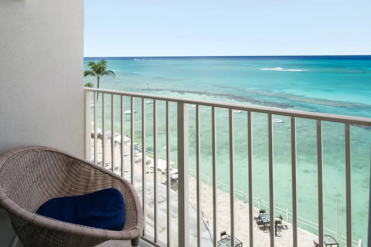 Oceanfront suite balcony chair overlooking beach and sea at Grand Cayman Marriott Resort.