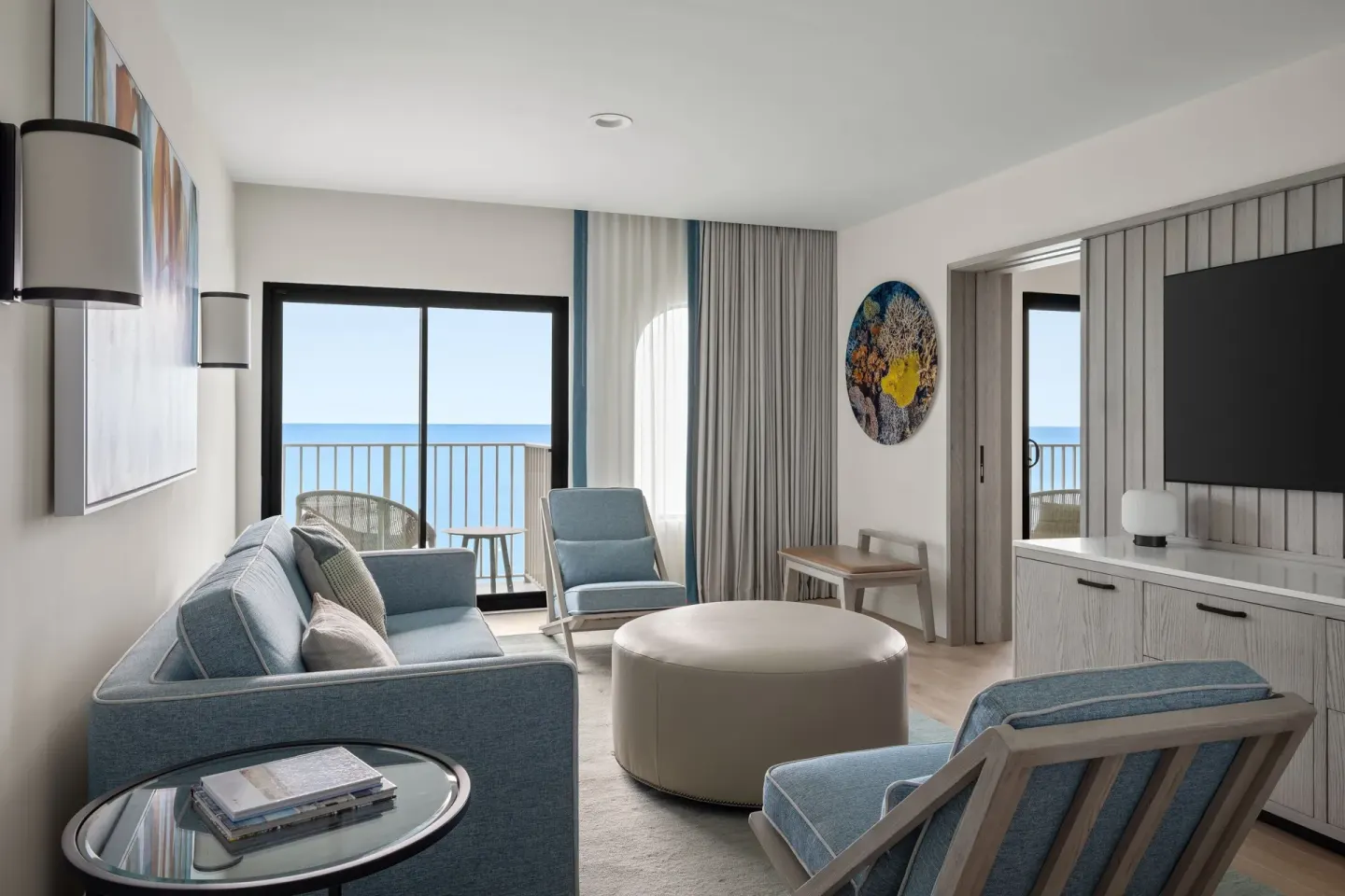 Oceanfront suite living room with sofa and balcony doors at Grand Cayman Marriott Resort.