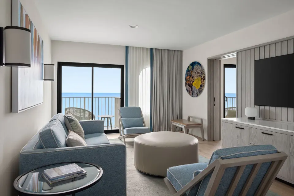 Oceanfront suite living room with sofa and balcony doors at Grand Cayman Marriott Resort.