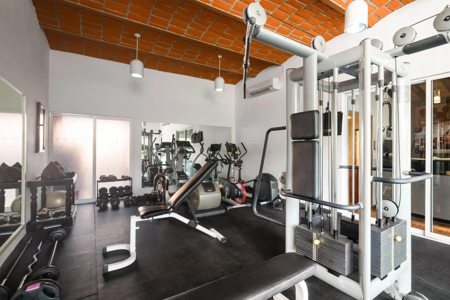 Fitness room with weight machines and cardio equipment at Grand Decameron Complex Bucerias.
