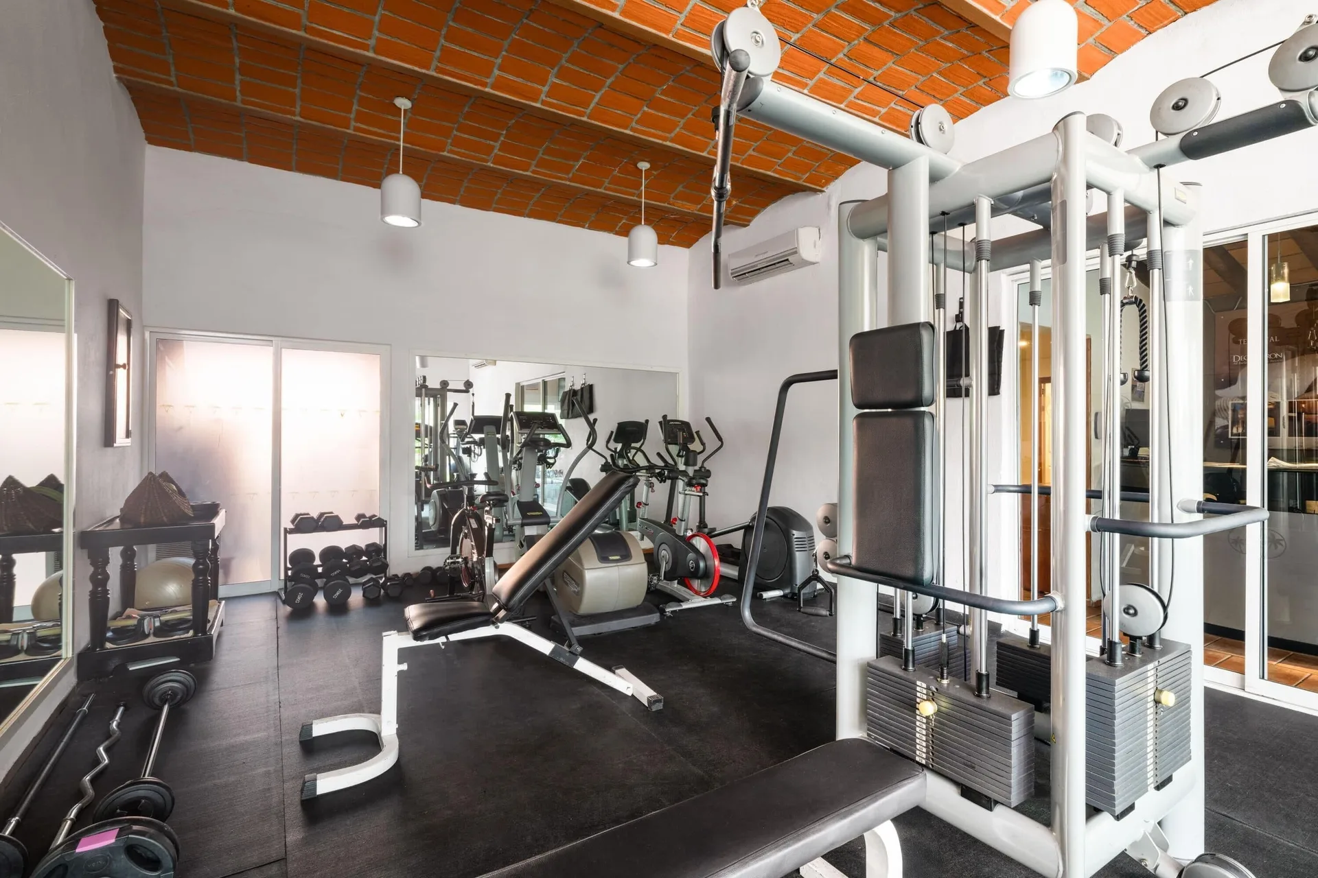 Fitness room with weight machines and cardio equipment at Grand Decameron Complex Bucerias.