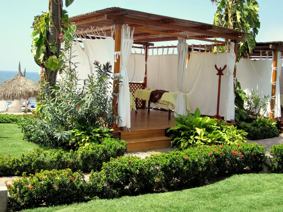 Garden spa cabana with curtains and massage tables at Grand Decameron Complex Bucerias.