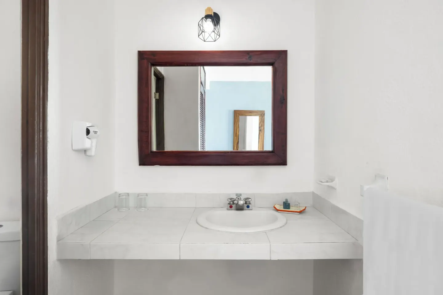 Simple guest bathroom vanity with framed mirror at Grand Decameron Complex Bucerias.