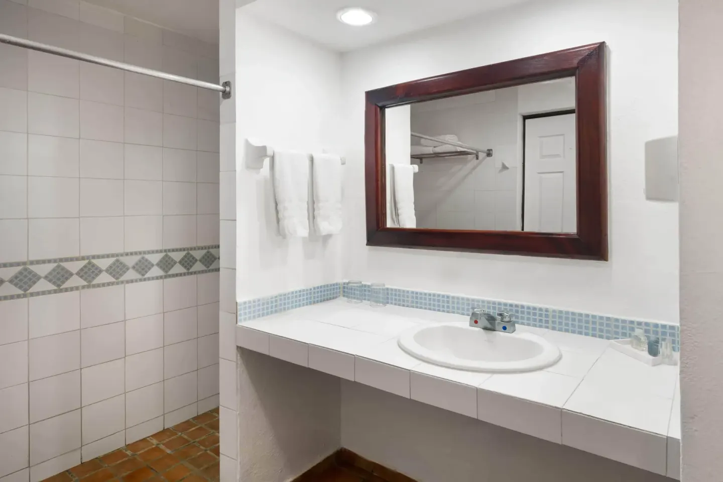 Guest bathroom with tiled shower and vanity at Grand Decameron Complex Bucerias.