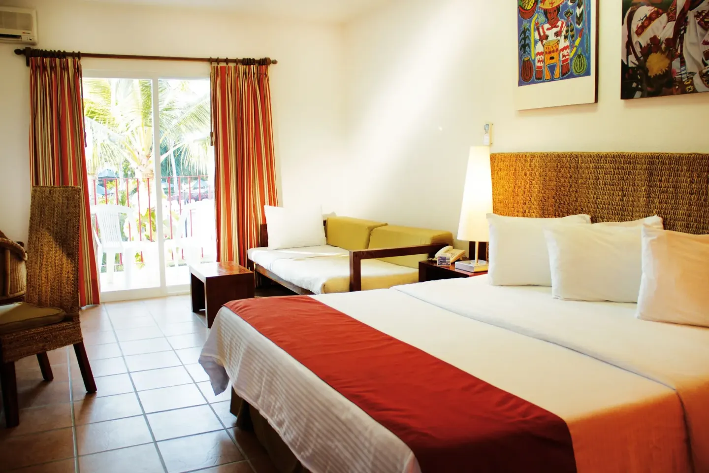Guest room with king bed, daybed and bright balcony doors at Grand Decameron Complex Bucerias.
