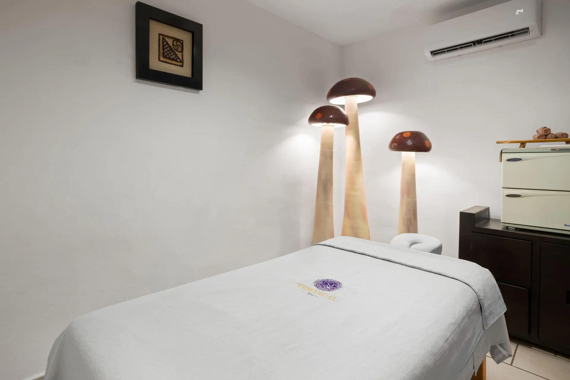 Massage treatment room with white table and mushroom-style lamps at Grand Decameron Complex Bucerias.