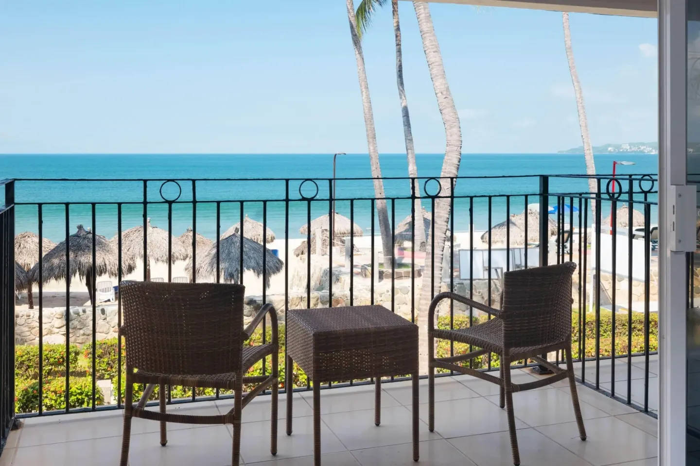 Furnished ocean-view balcony with wicker chairs at Grand Decameron Complex Bucerias.