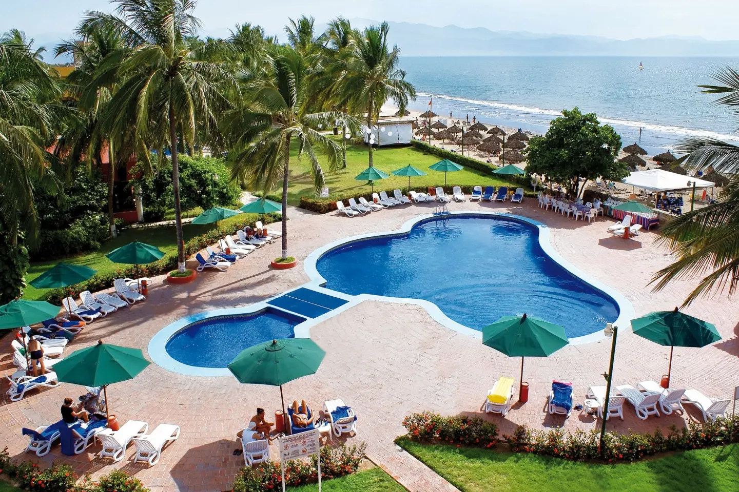 Aerial view of oceanfront pool and beach at Grand Decameron Complex Bucerias.