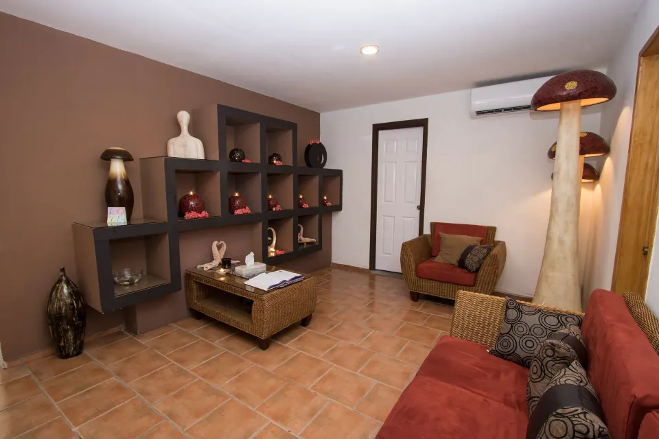 Spa lounge with red seating and decorative shelves at Grand Decameron Complex Bucerias.
