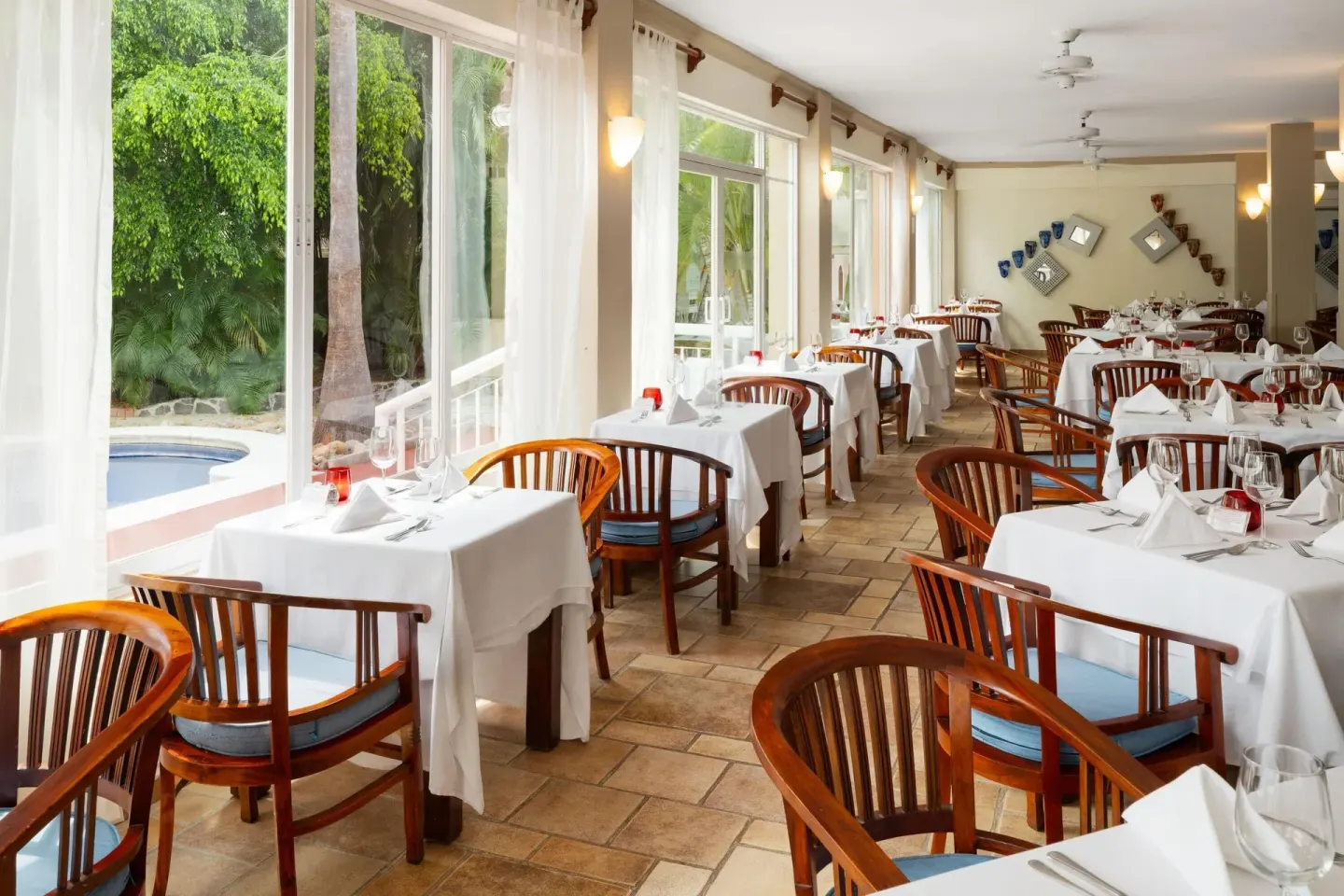 Bright indoor dining room with garden-facing windows at Grand Decameron Complex Bucerias.