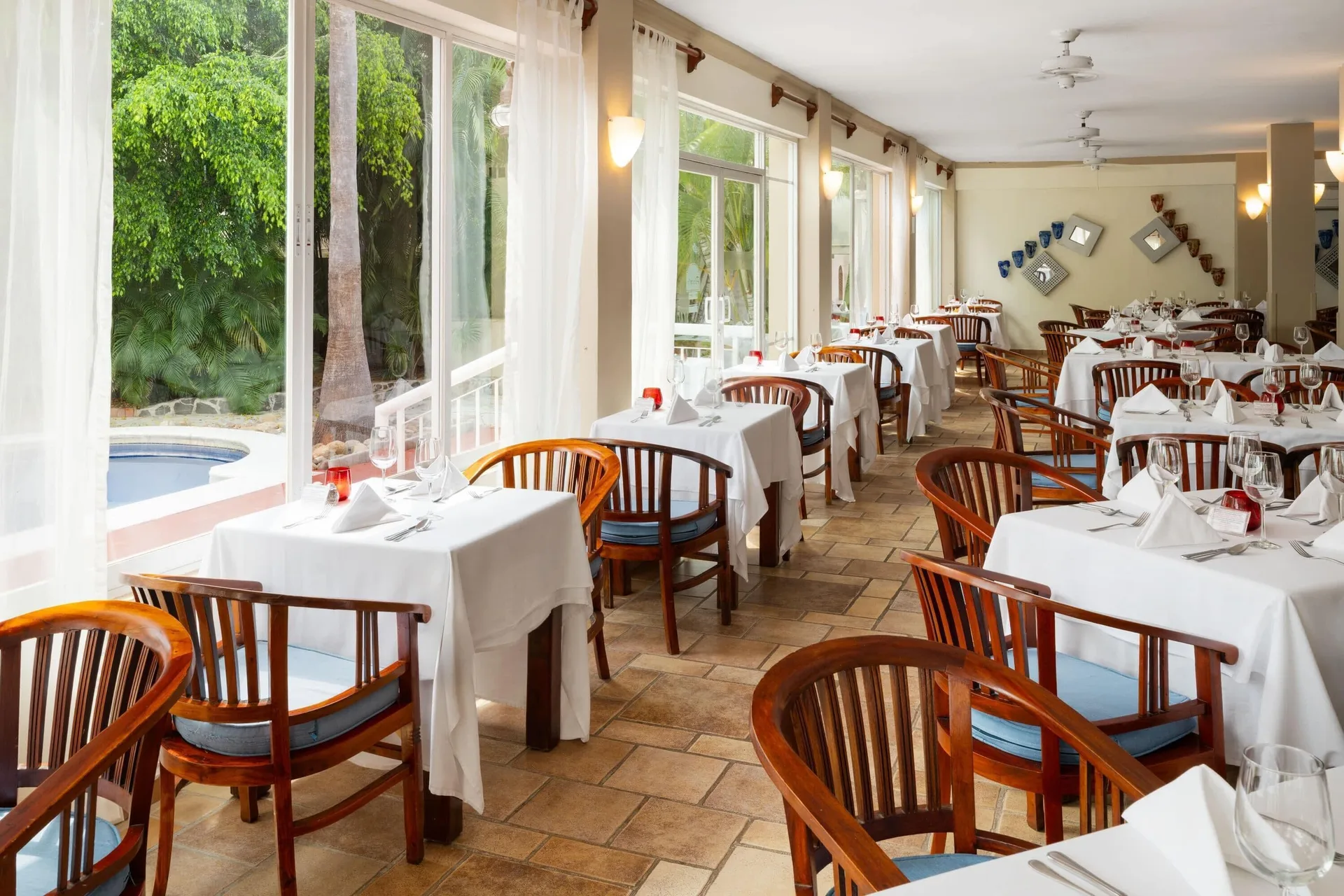 Bright indoor dining room with garden-facing windows at Grand Decameron Complex Bucerias.