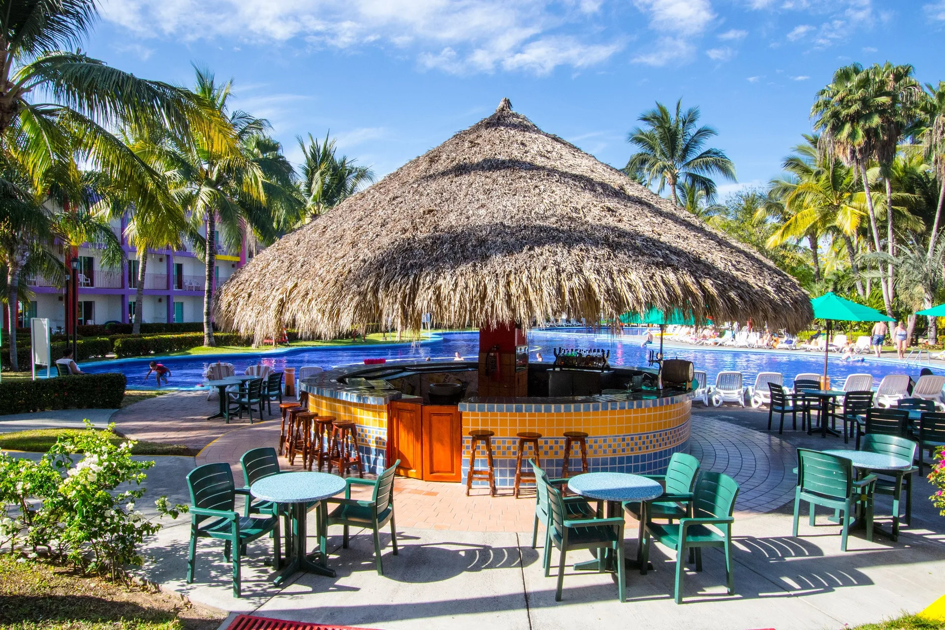 Poolside palapa bar with tables at Grand Decameron Complex Bucerias.