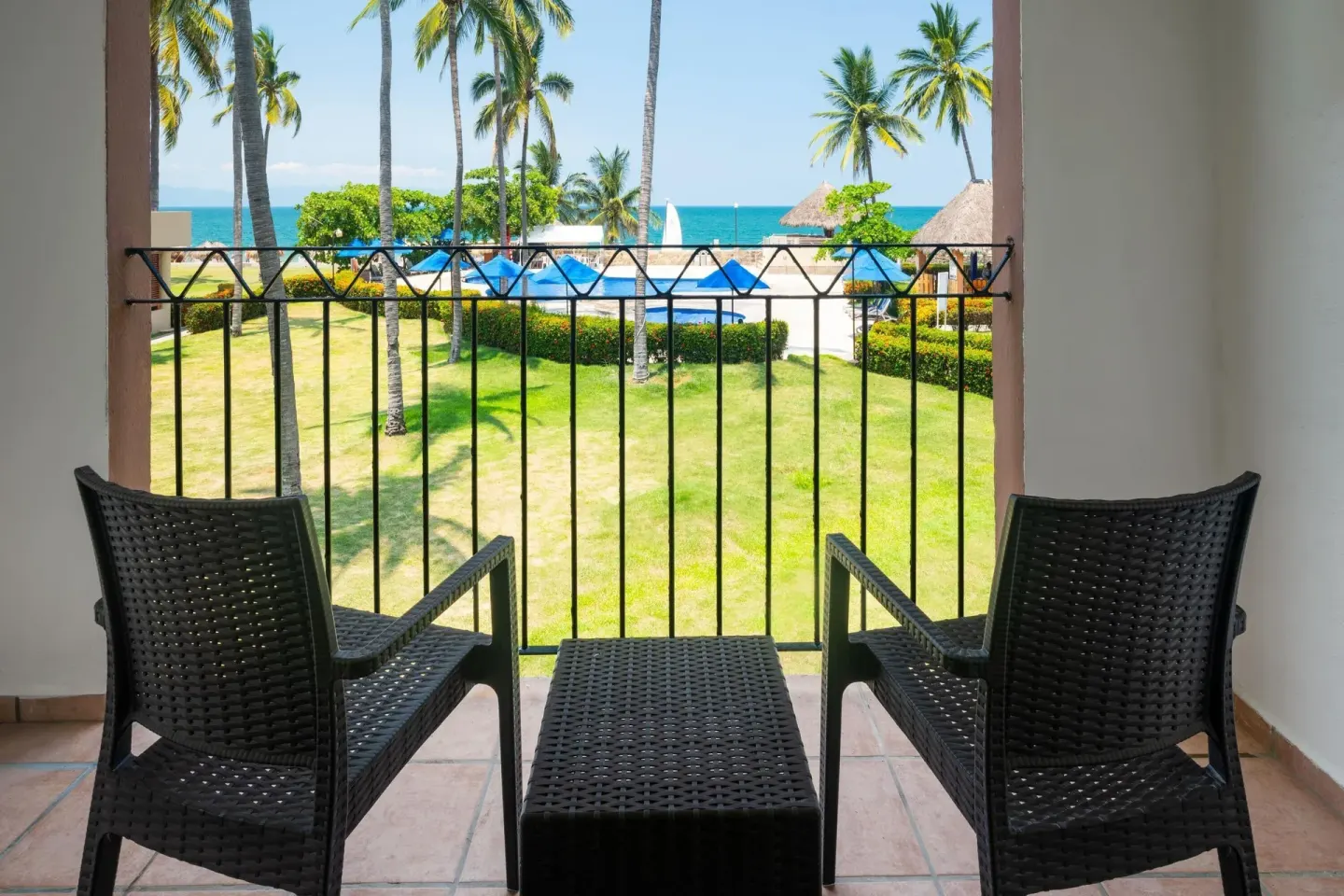 Ocean View Room balcony with chairs and ocean view at Grand Decameron Complex Bucerias.