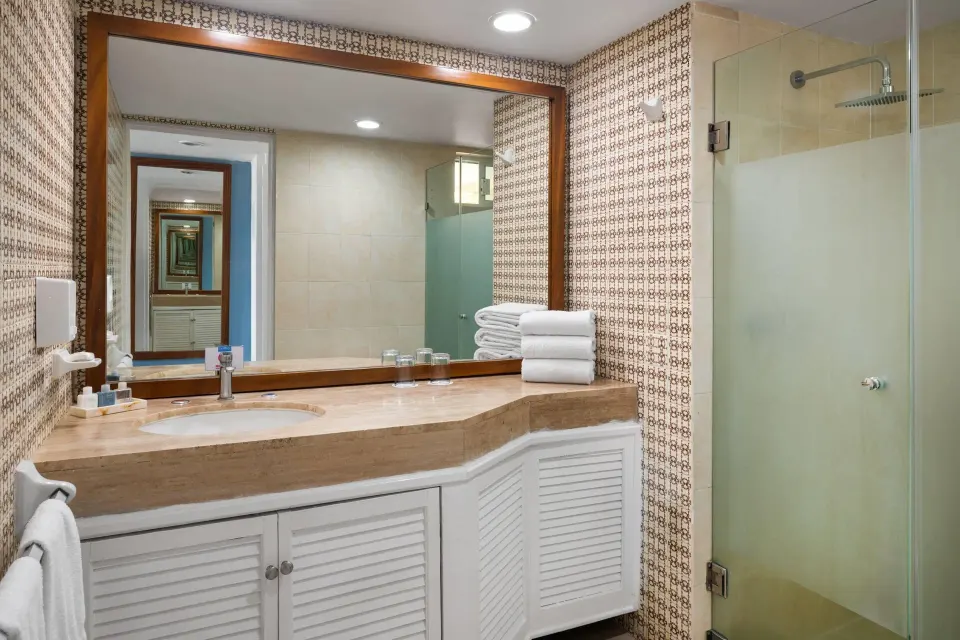 Ocean View room bathroom with vanity and glass shower at Grand Decameron Complex Bucerias.