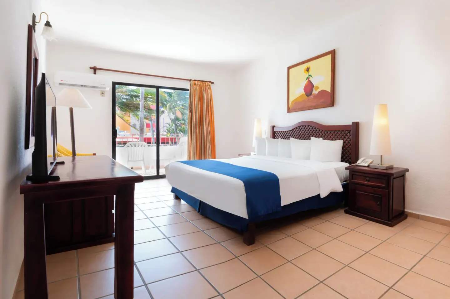 Ocean View Room with king bed, TV, and balcony doors at Grand Decameron Complex Bucerias.