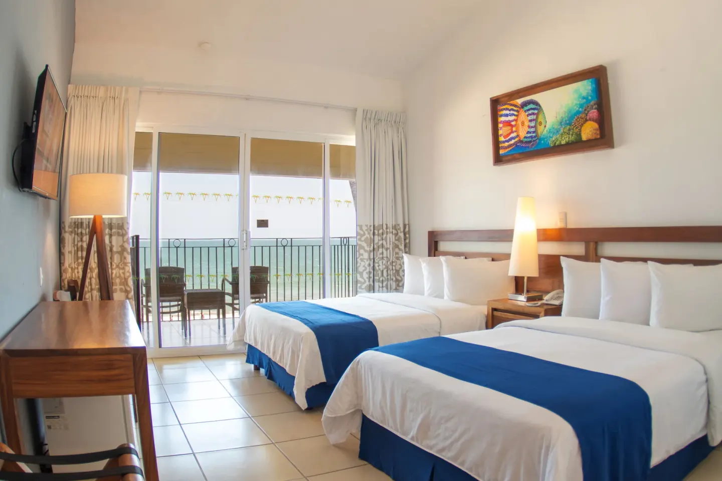 Ocean View room with two double beds and balcony doors at Grand Decameron Complex Bucerias.