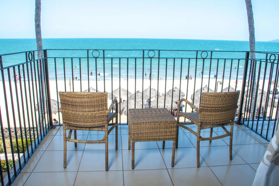 Oceanfront balcony with chairs overlooking the beach at Grand Decameron Complex Bucerias.