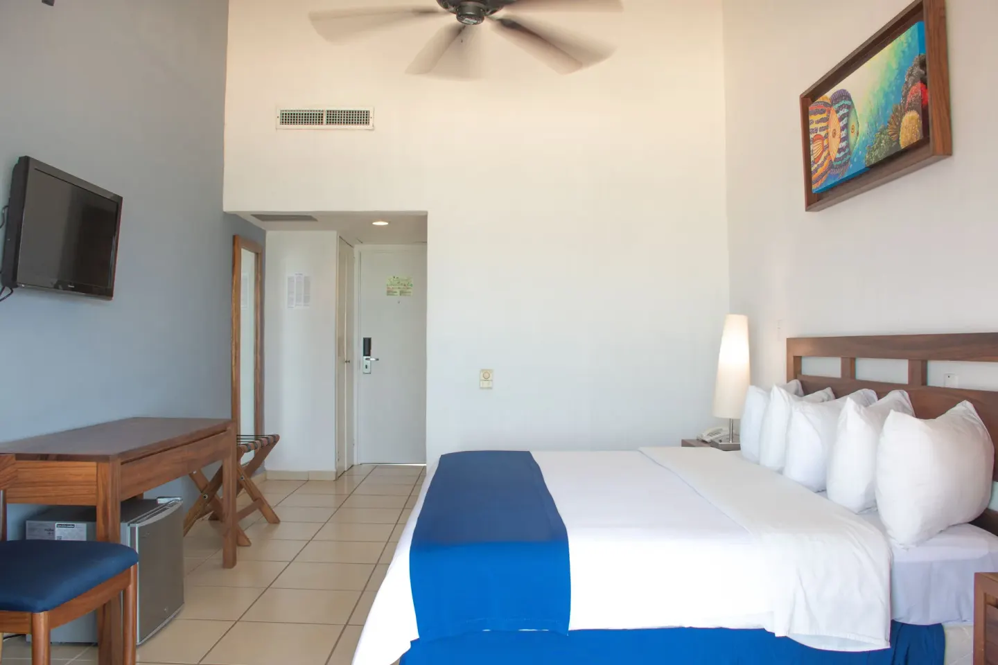 Oceanfront room with king bed, TV, desk, and entry area at Grand Decameron Complex Bucerias.