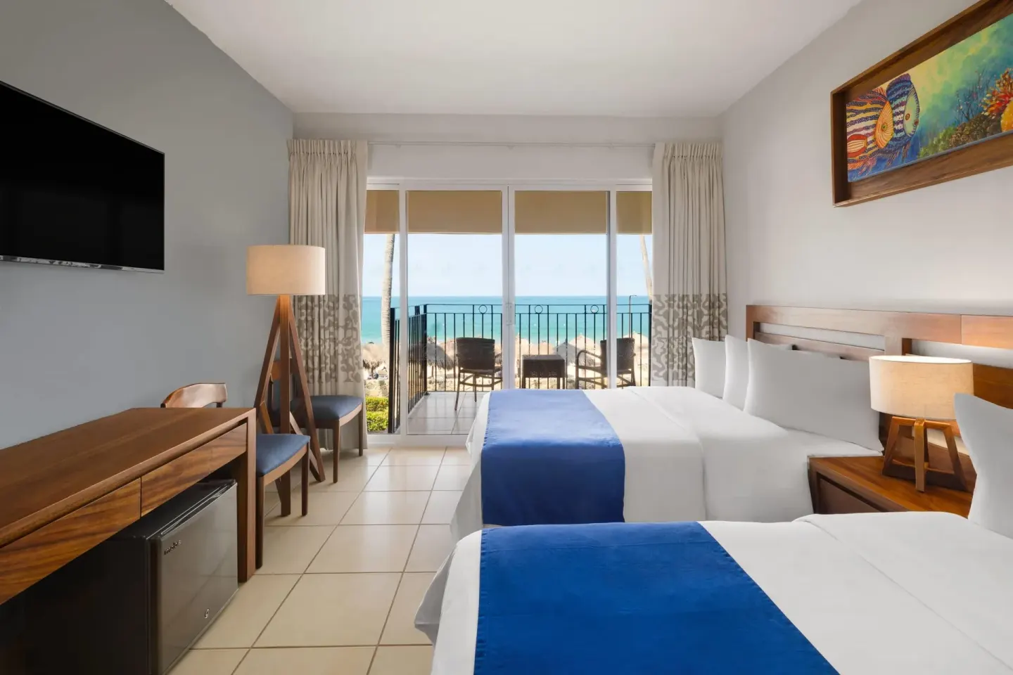 Oceanfront room with two beds facing a balcony at Grand Decameron Complex Bucerias.
