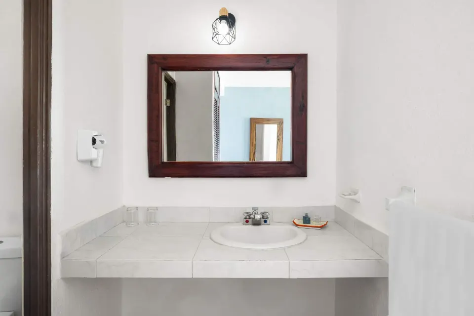 Standard Room bathroom vanity with mirror at Grand Decameron Complex Bucerias.