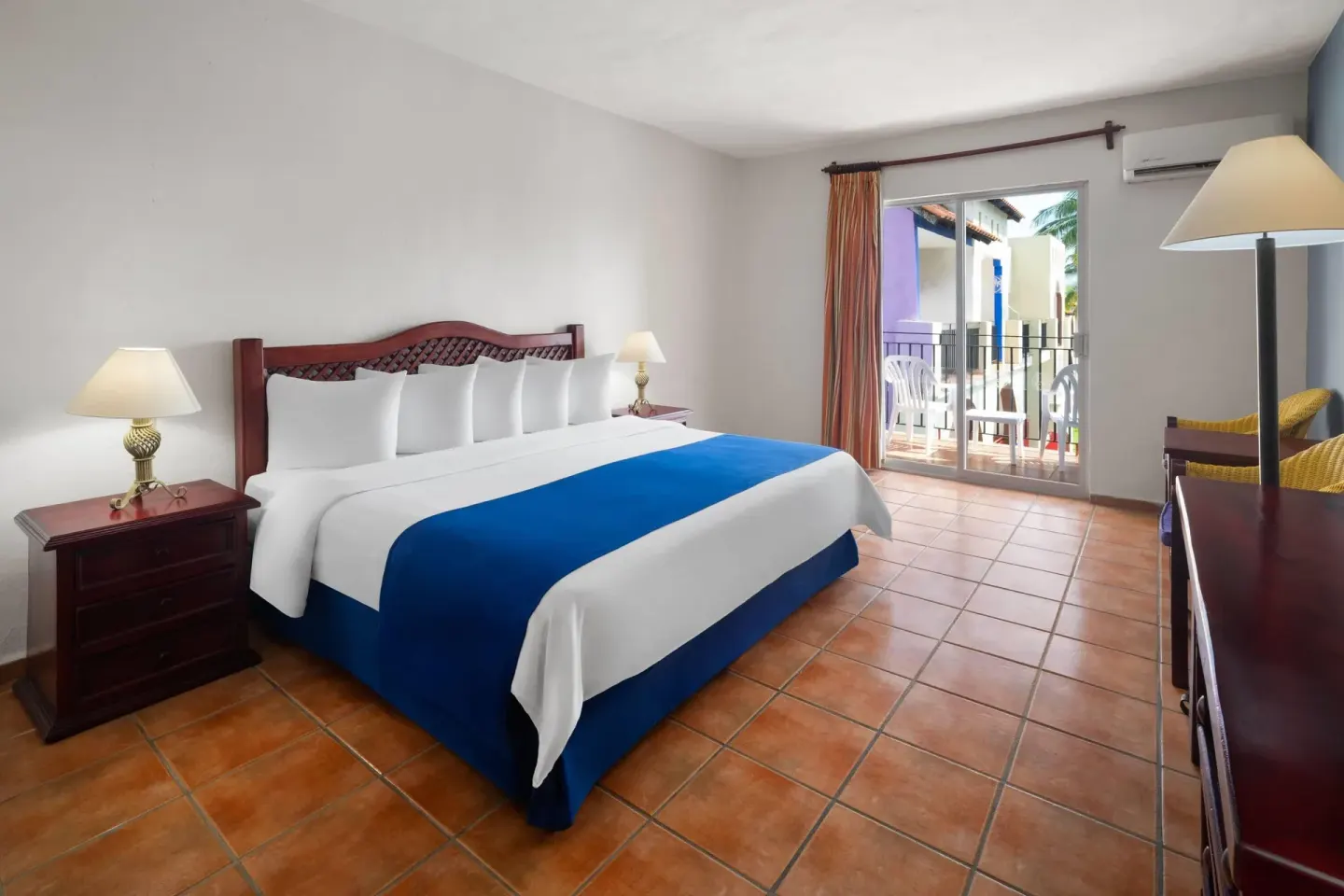 Standard Room with king bed and balcony seating at Grand Decameron Complex Bucerias.