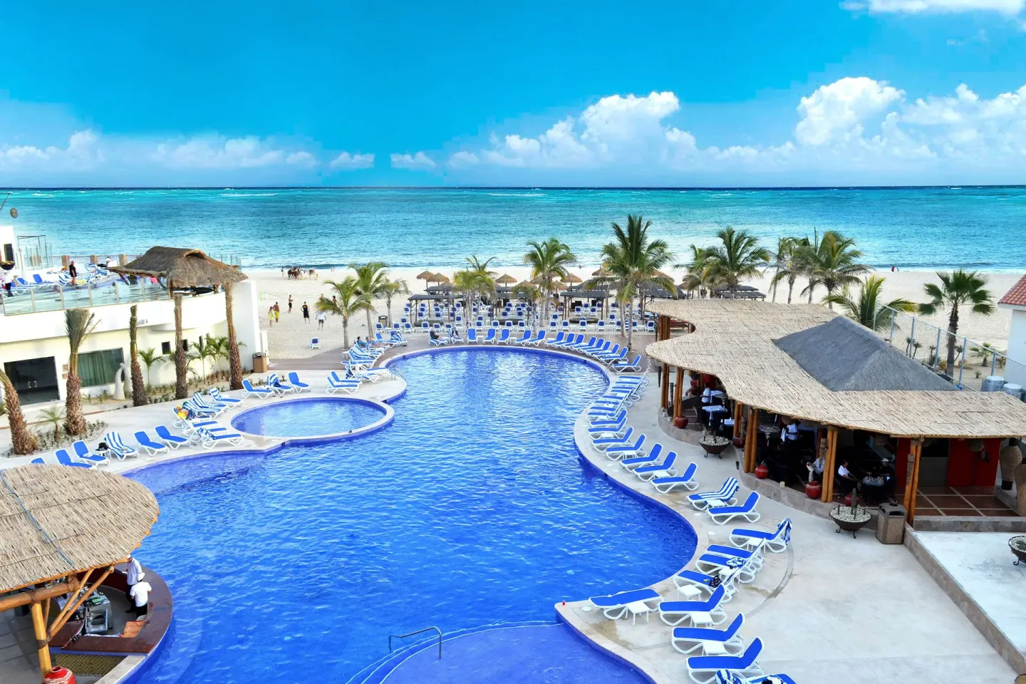 Aerial view of beachfront pool and ocean at Grand Decameron Los Cabos.