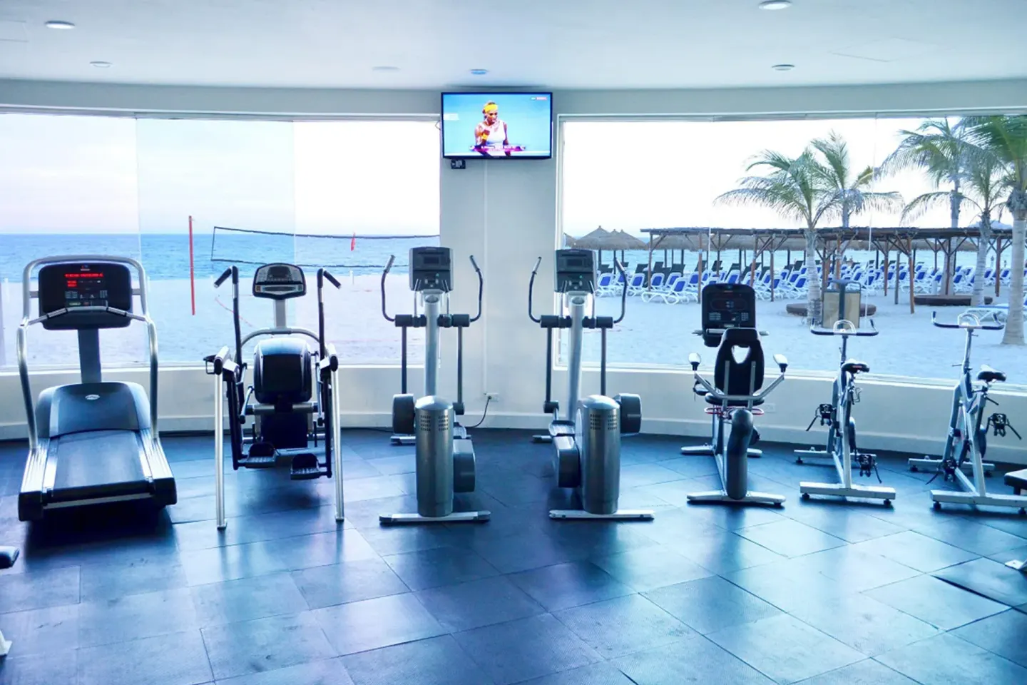 Cardio equipment facing beach windows in the gym at Grand Decameron Los Cabos.