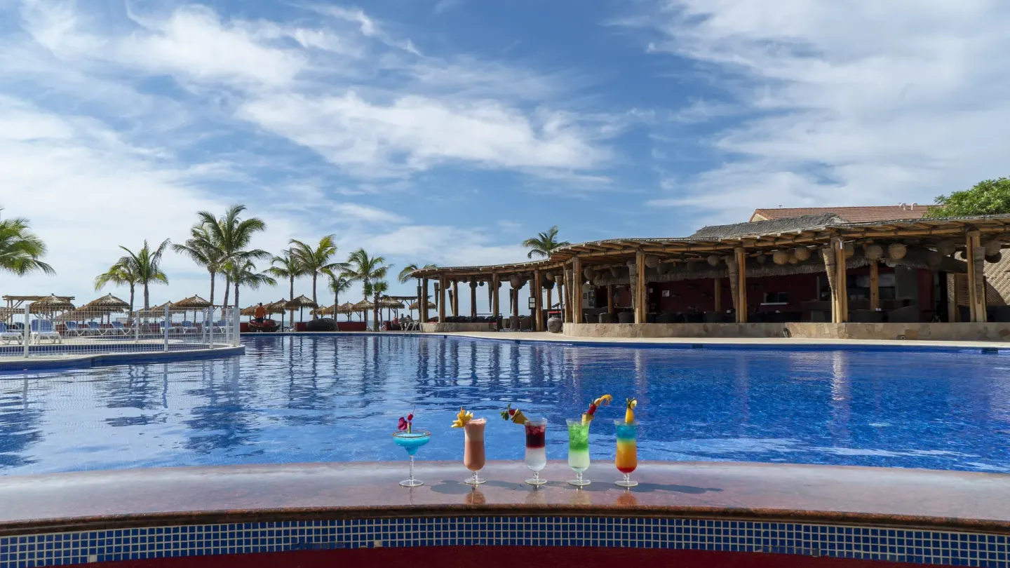 Colorful cocktails line the pool edge at Grand Decameron Los Cabos.