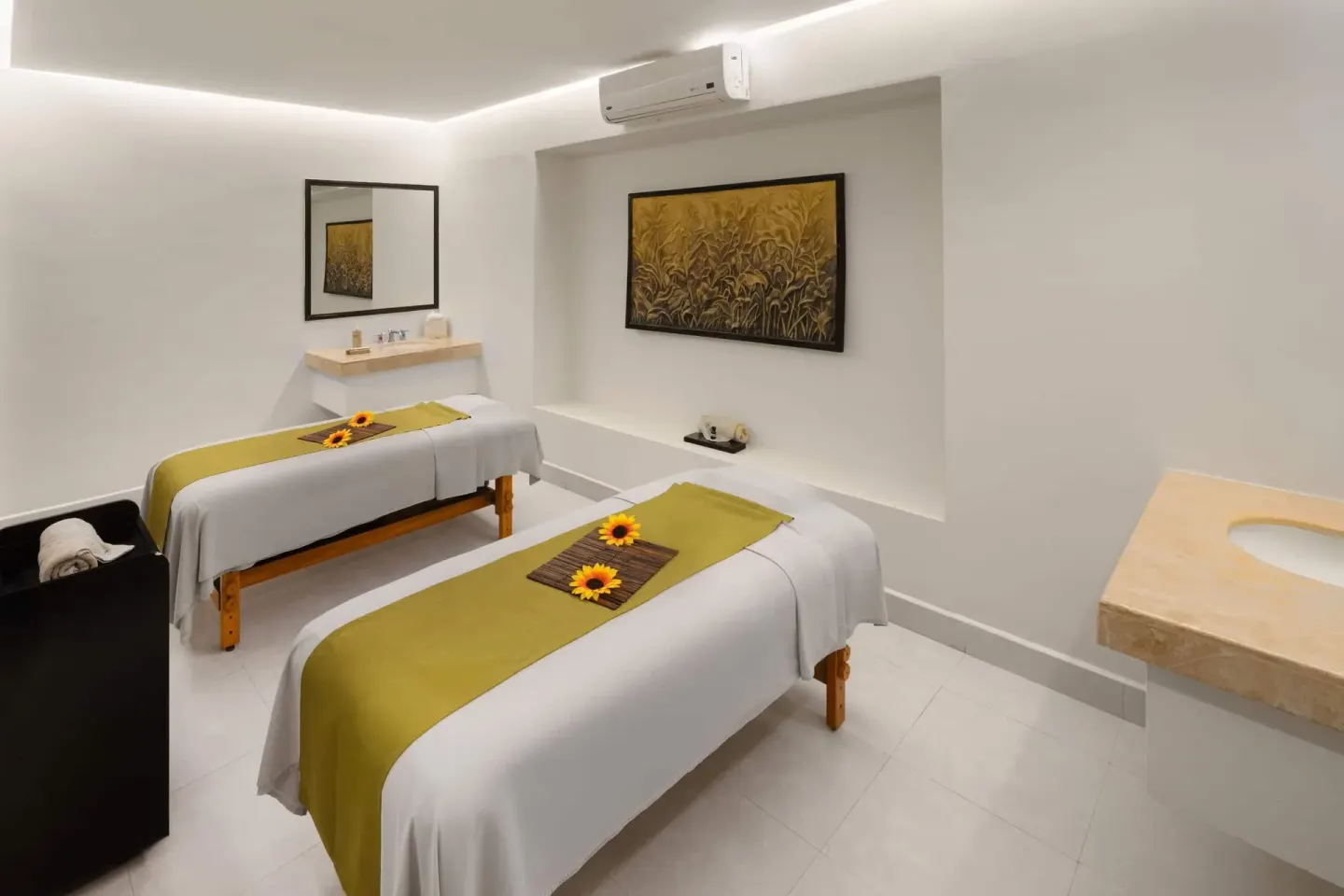 Spa room with two massage beds and flower accents at Grand Decameron Los Cabos.