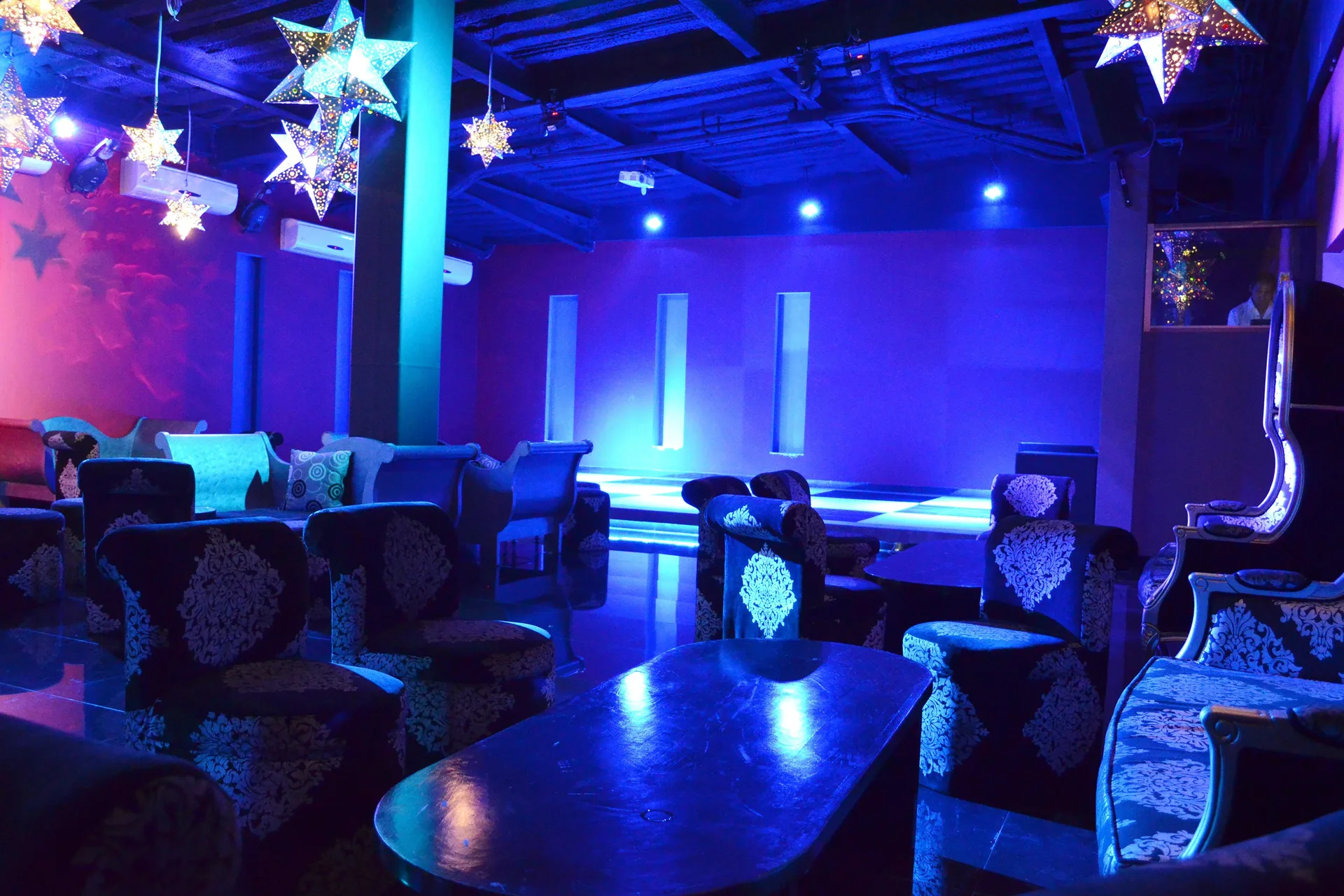 Blue-lit lounge seating and stage area at Grand Decameron Los Cabos.