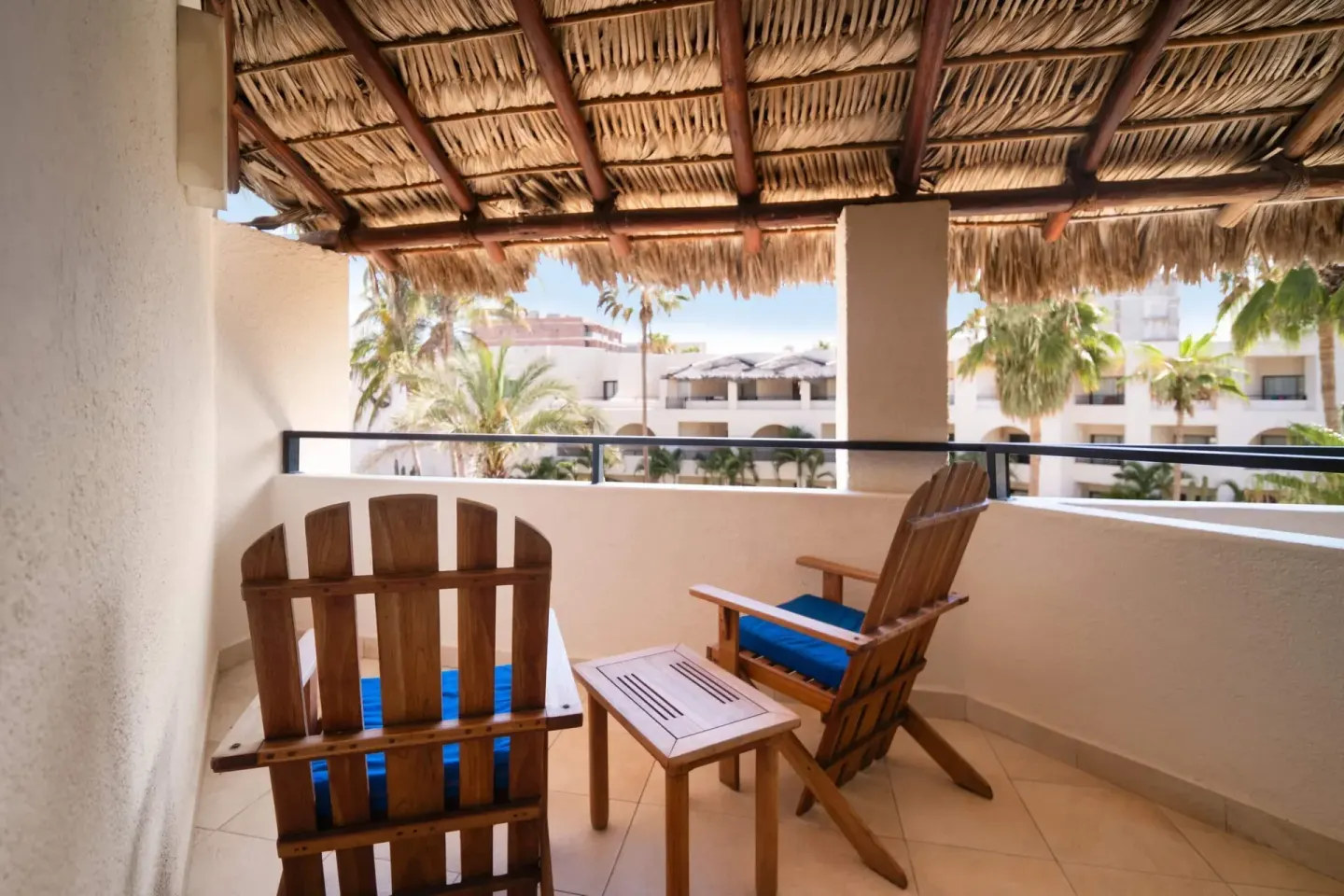 Standard Room balcony with wooden chairs at Grand Decameron Los Cabos.