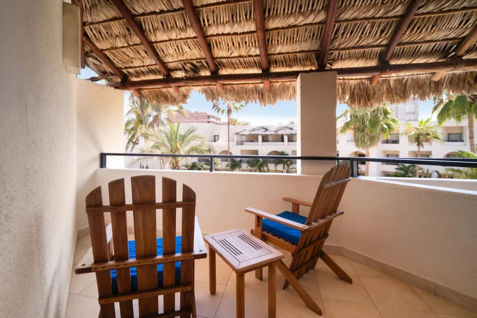 Standard Room balcony with wooden chairs at Grand Decameron Los Cabos.