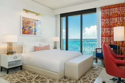 Ocean-view king room with red chair and balcony at Grand Hyatt Baha Mar.