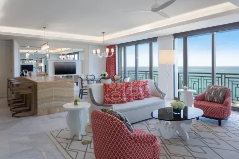 Oceanfront suite living room with red chairs at Grand Hyatt Baha Mar.