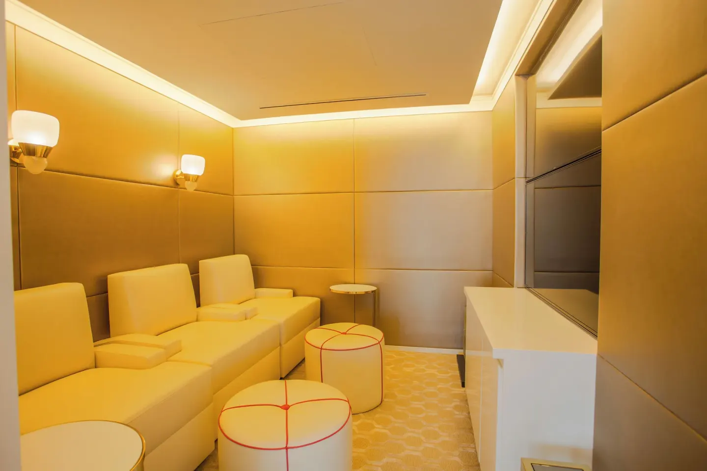 Private lounge with cream seating and wall-mounted TV at Grand Hyatt Baha Mar.