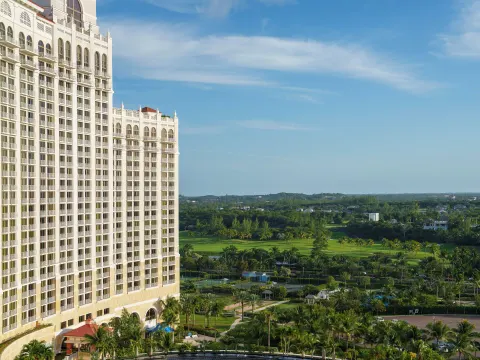 Tall resort tower overlooking green grounds and distant fairways at Grand Hyatt Baha Mar.