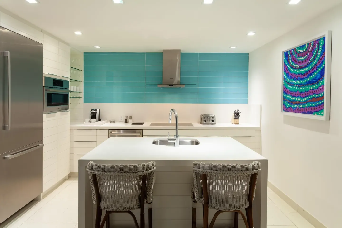 Suite kitchen with island seating and turquoise backsplash at Grand Hyatt Baha Mar.