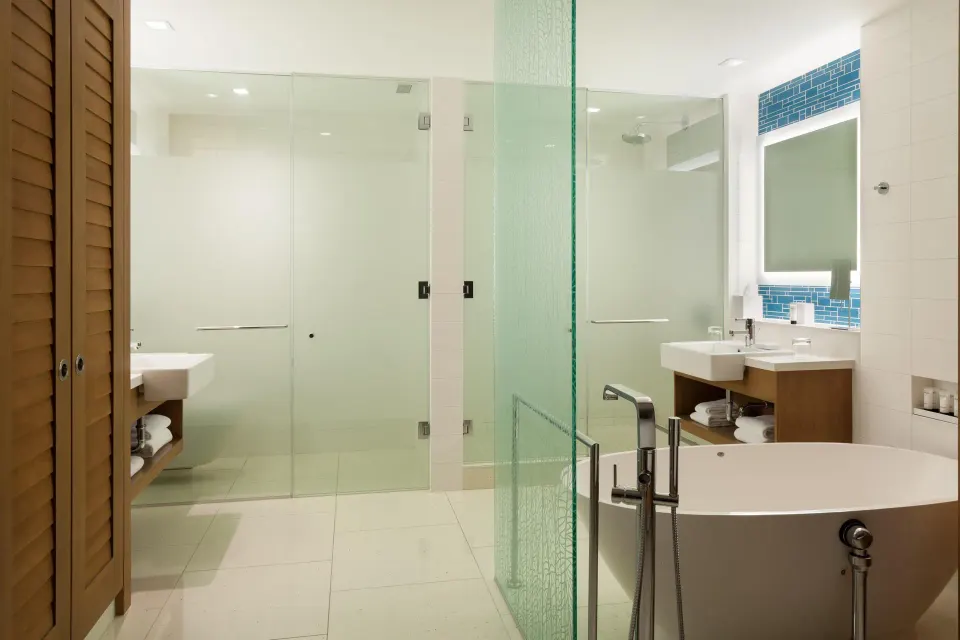 Bathroom with soaking tub and glass shower in a Deluxe Room residence at Grand Hyatt Baha Mar.