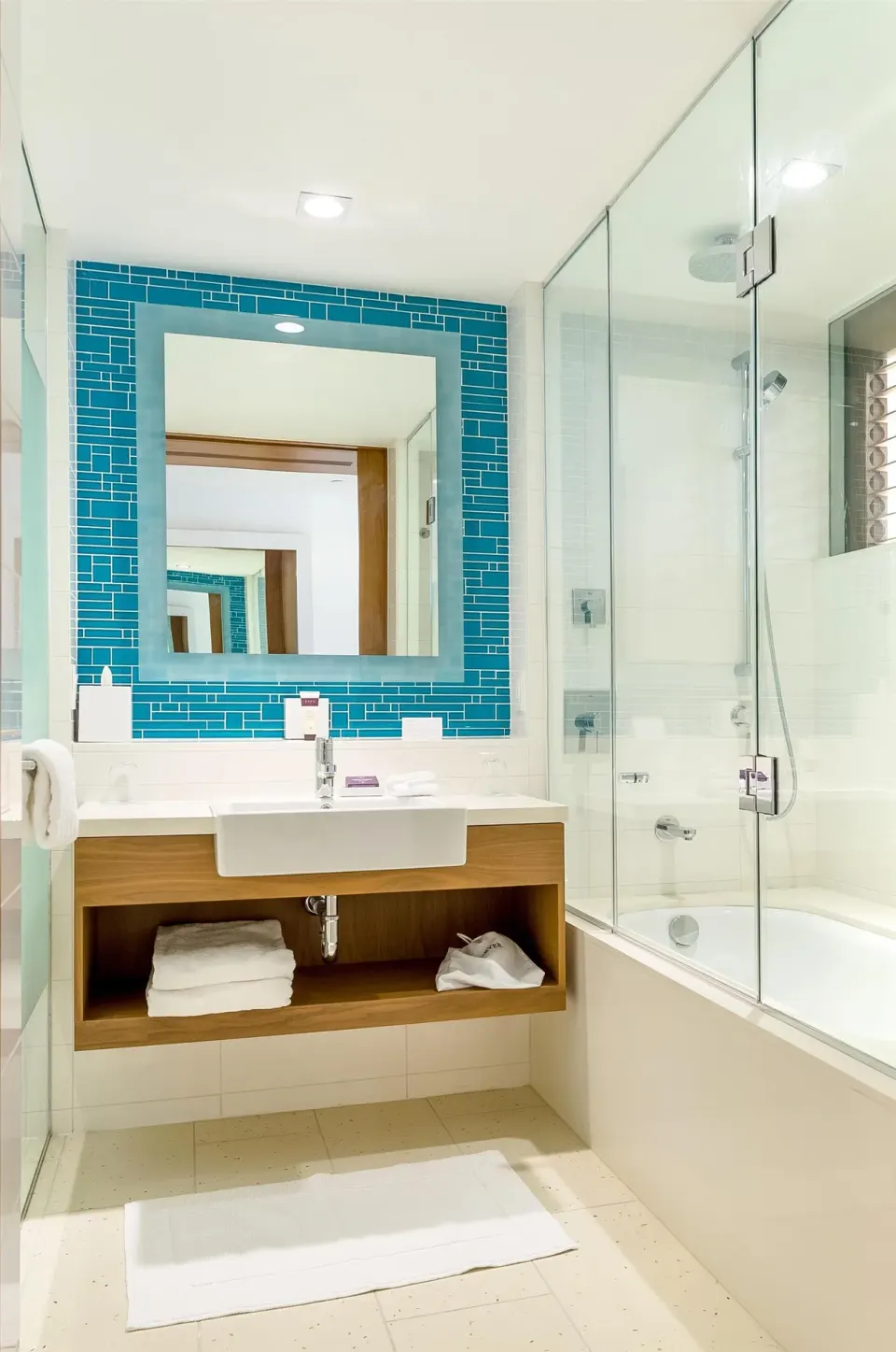 Grand Room bathroom with blue tile mirror and shower-over-tub at Grand Hyatt Baha Mar.