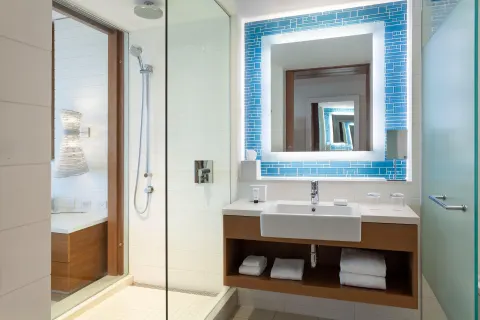 Grand Room bathroom with glass shower and blue tile mirror at Grand Hyatt Baha Mar.
