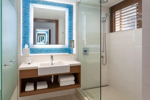 Grand Room bathroom with walk-in shower, vanity, and louvered window at Grand Hyatt Baha Mar.