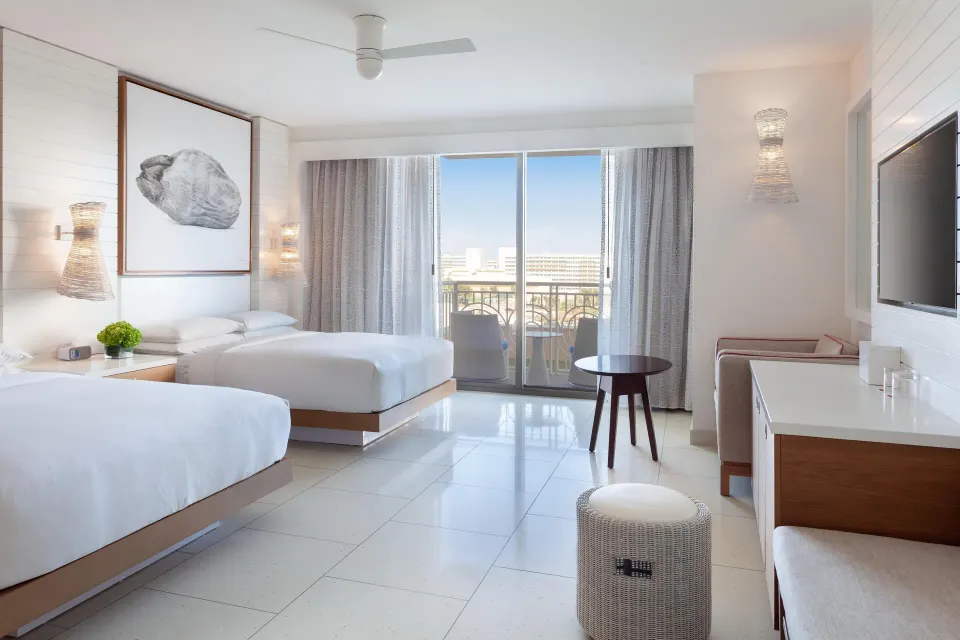 Grand Room with two beds, balcony doors, seating, and TV at Grand Hyatt Baha Mar.