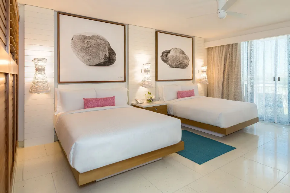 Two double beds in a Grand Room at Grand Hyatt Baha Mar with wall art and balcony curtains.