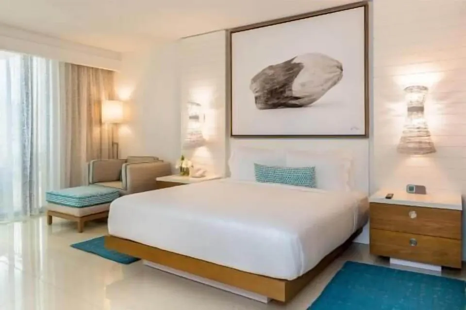 King bedroom with lounge chair and framed wall art at Grand Hyatt Baha Mar.