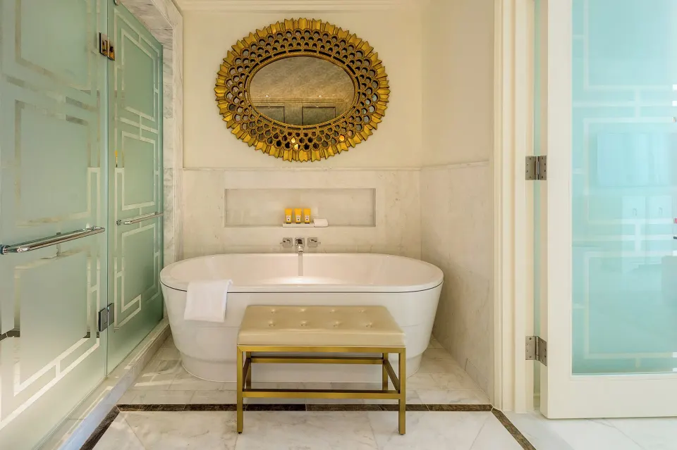 Bathtub, shower doors, and gold mirror in a residence bathroom at Grand Hyatt Baha Mar.