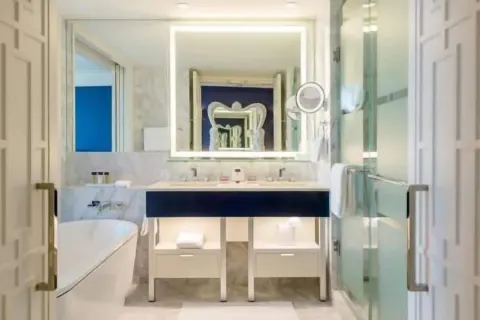 Bright marble bathroom in a room at Grand Hyatt Baha Mar with tub, vanity, and glass shower.