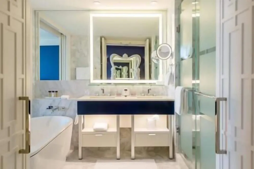 Bright marble bathroom in a room at Grand Hyatt Baha Mar with tub, vanity, and glass shower.