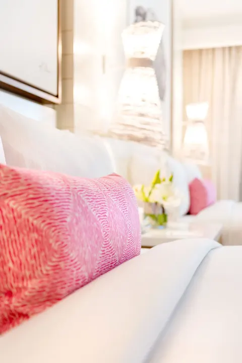 Close-up of a pink pillow on a white bed in a room at Grand Hyatt Baha Mar.
