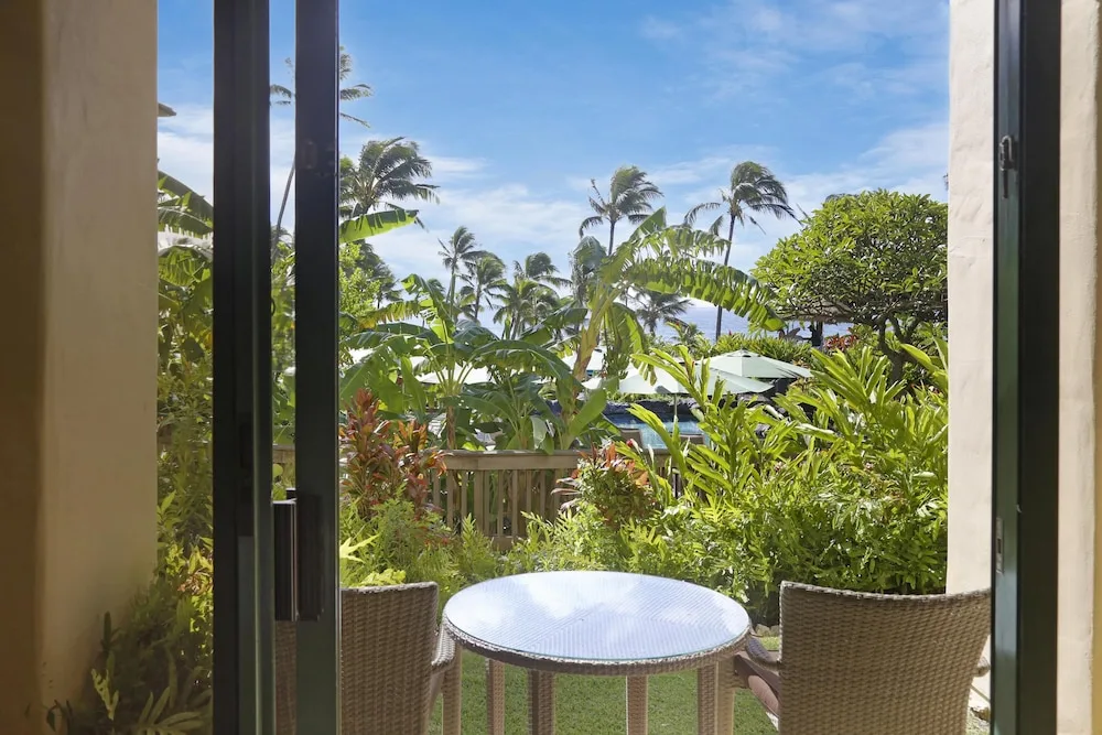 Guest room patio surrounded by tropical plants at Grand Hyatt Kauai Resort and Spa and Spa.